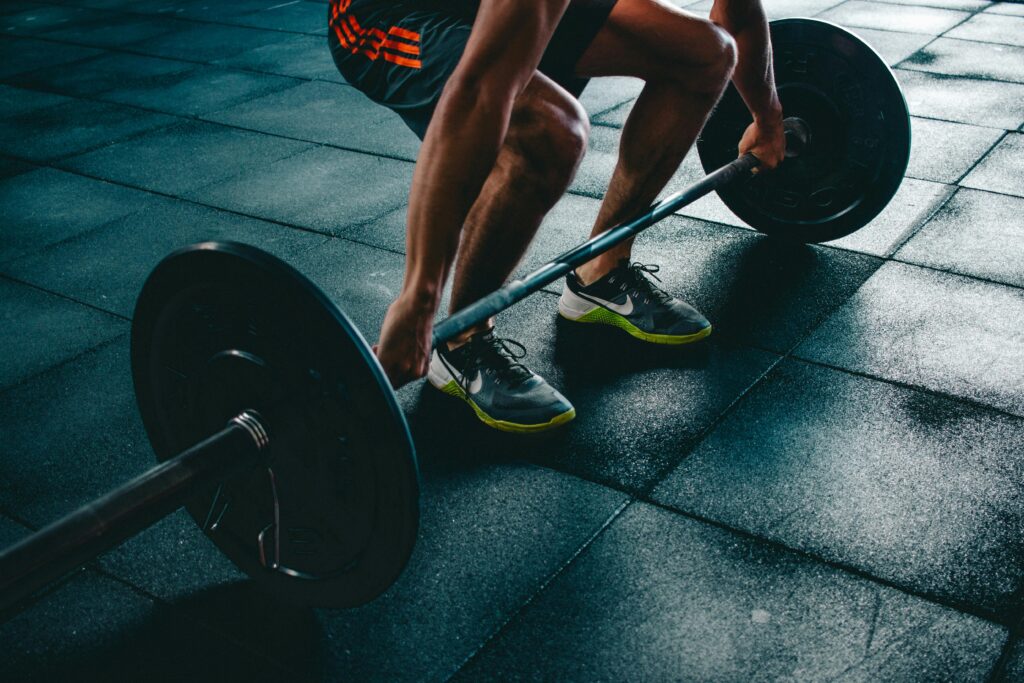 Man performing a deadlift exercise in a gym, demonstrating strength and fitness.